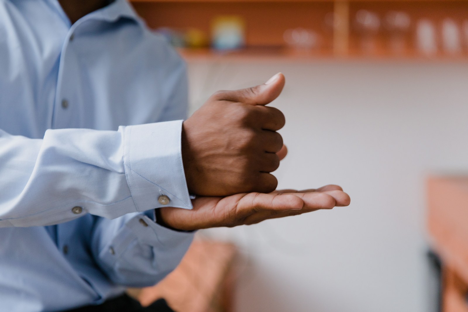 A close view of a hand forming a sign language gesture, practiced at home.