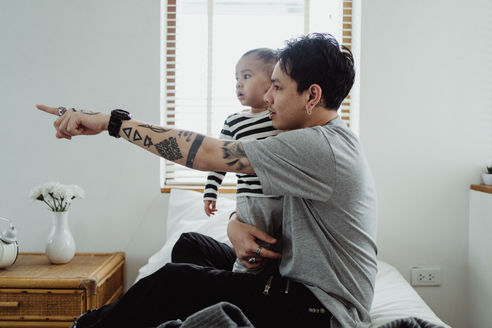 A parent pointing at an object while making eye contact with their toddler.